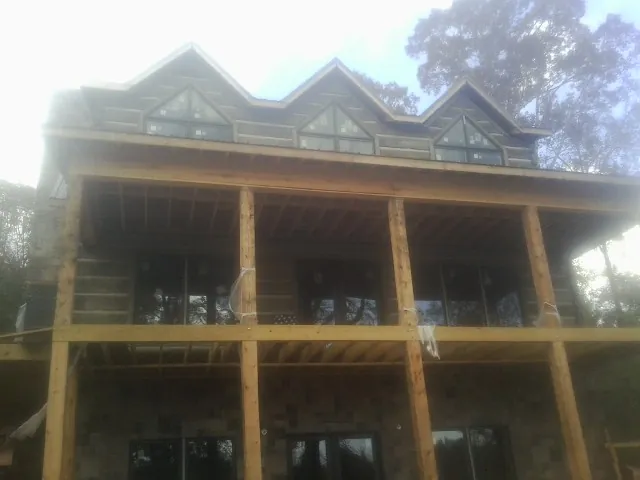Dormers and porch framing on a large log home under construction — Roof Coating work by our crew in Ferndale